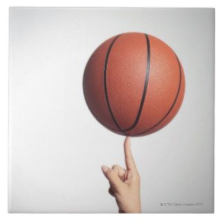 Basketball on index finger,hands close up ceramic tile