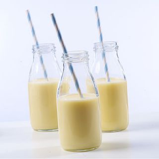 set of three retro milk bottles with straws by feather grey parties