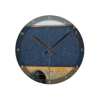 Blue Roof Tiles Of Vintage Stone House Against Blu Wall Clocks